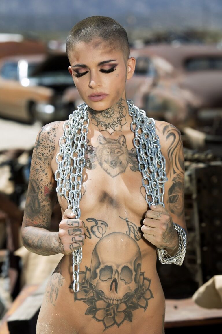 13P Das kahlköpfige, tätowierte Babe Leigh Raven stellt ihre kleinen Brüste zur Schau und posiert nackt im Freien