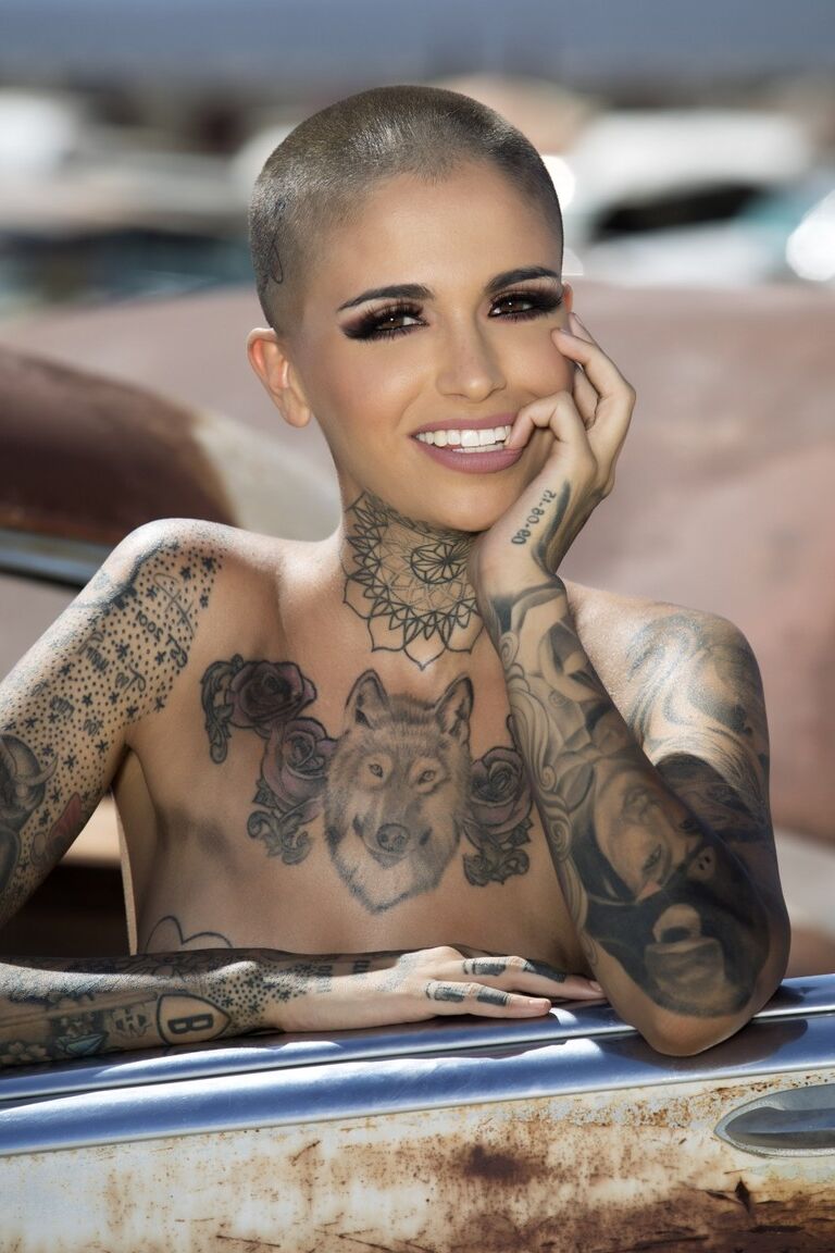 13P Das kahlköpfige, tätowierte Babe Leigh Raven stellt ihre kleinen Brüste zur Schau und posiert nackt im Freien