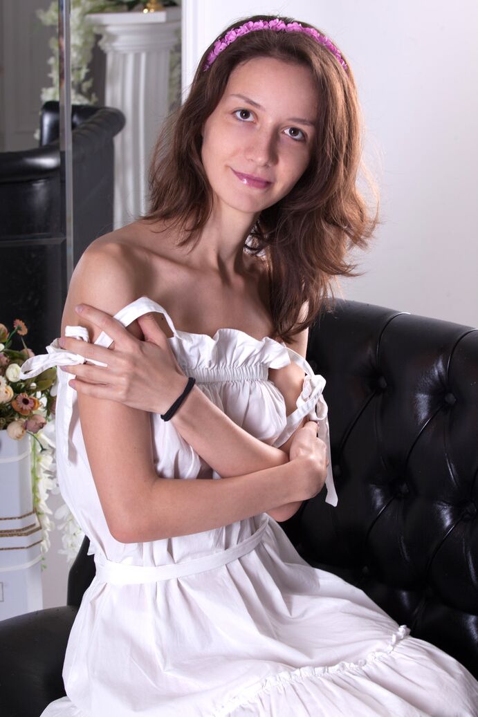 16P Young looking girl Gabi dons a funky pink hat for a nude modeling session