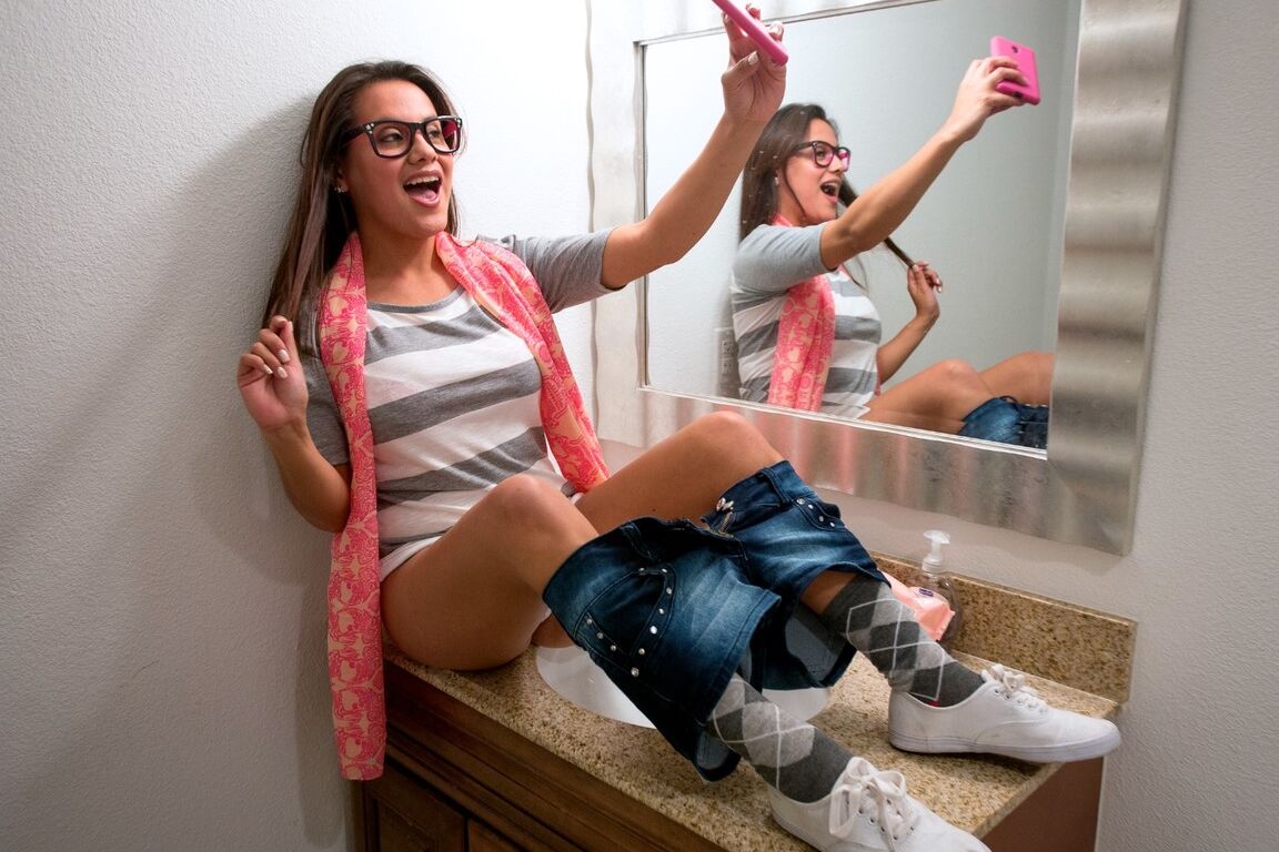 20P Selma Sins, une jeune à lunettes, révèle ses jolis seins naturels pour prendre un selfie sexy
