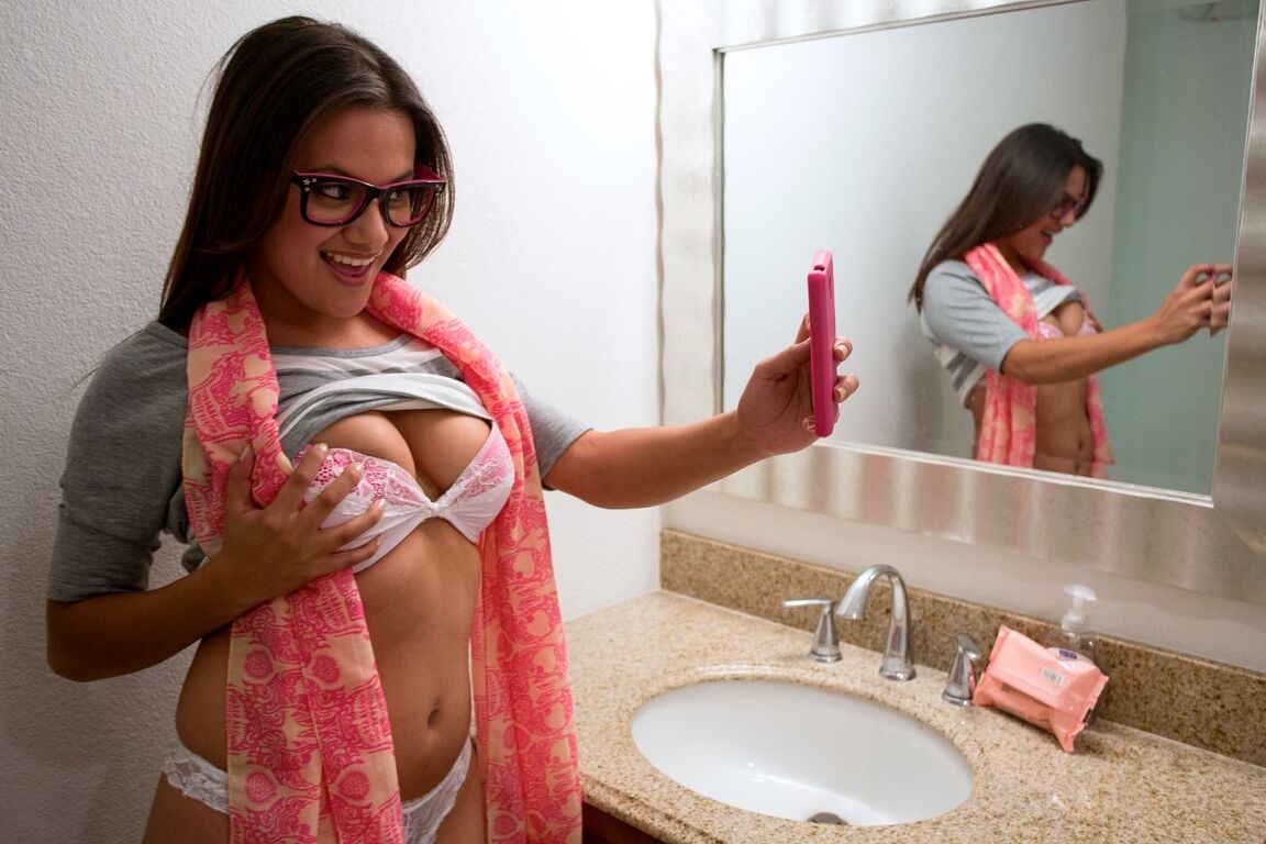 20P Selma Sins, une jeune à lunettes, révèle ses jolis seins naturels pour prendre un selfie sexy