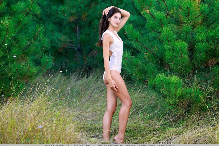 18P Young brunette Aleksandrina strikes great nude poses in front of fir trees