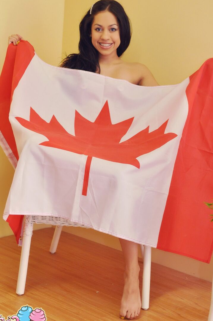 12P La linda adolescente canadiense Cindy Cupcakes sostiene una bandera antes de mostrar su cuerpo desnudo