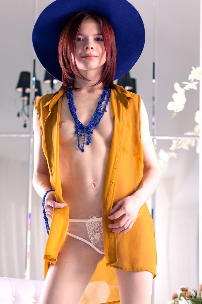 20P Adolescente de pele clara e cabelo ruivo faz poses sensuais de nudez com um chapéu de sol