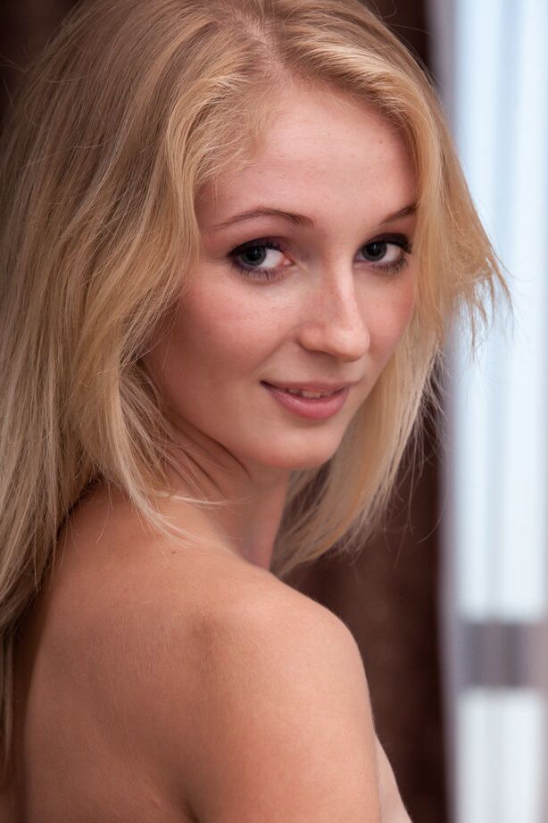 Die 18-jährige blonde Teenagerin Leona Honey zieht ihren BH und Tanga aus, um nackt zu posieren