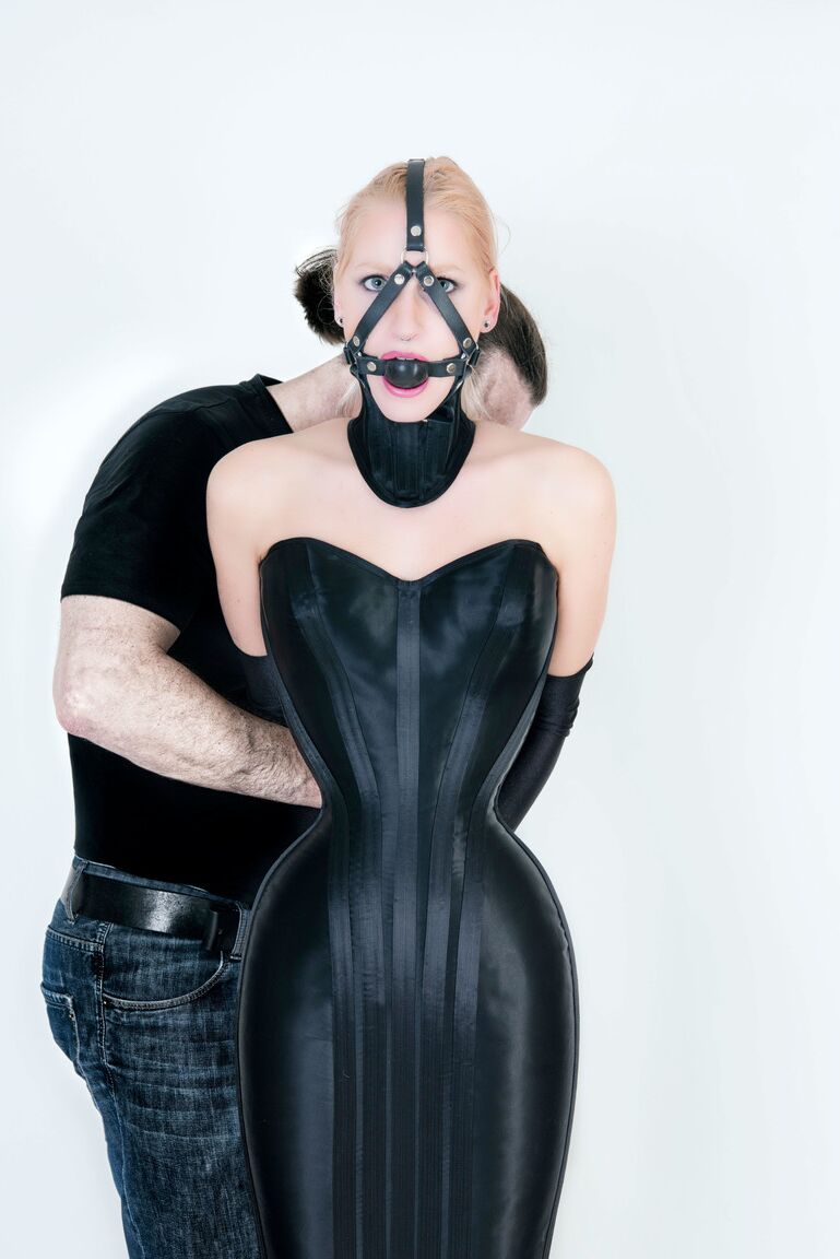 16P Blonde chick Arienh Autumn is fitted with a ball gag harness in a Hobbledress