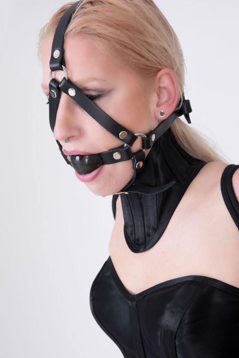 16P Blonde chick Arienh Autumn is fitted with a ball gag harness in a Hobbledress