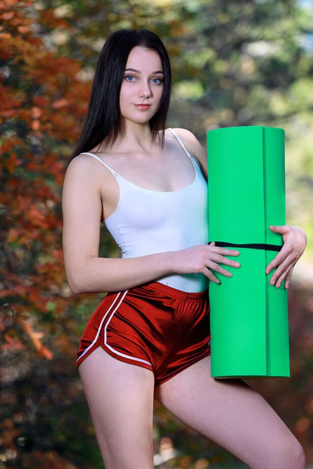 18P La joven de pelo oscuro Polly Pure se desnuda totalmente en el bosque sobre una estera de yoga