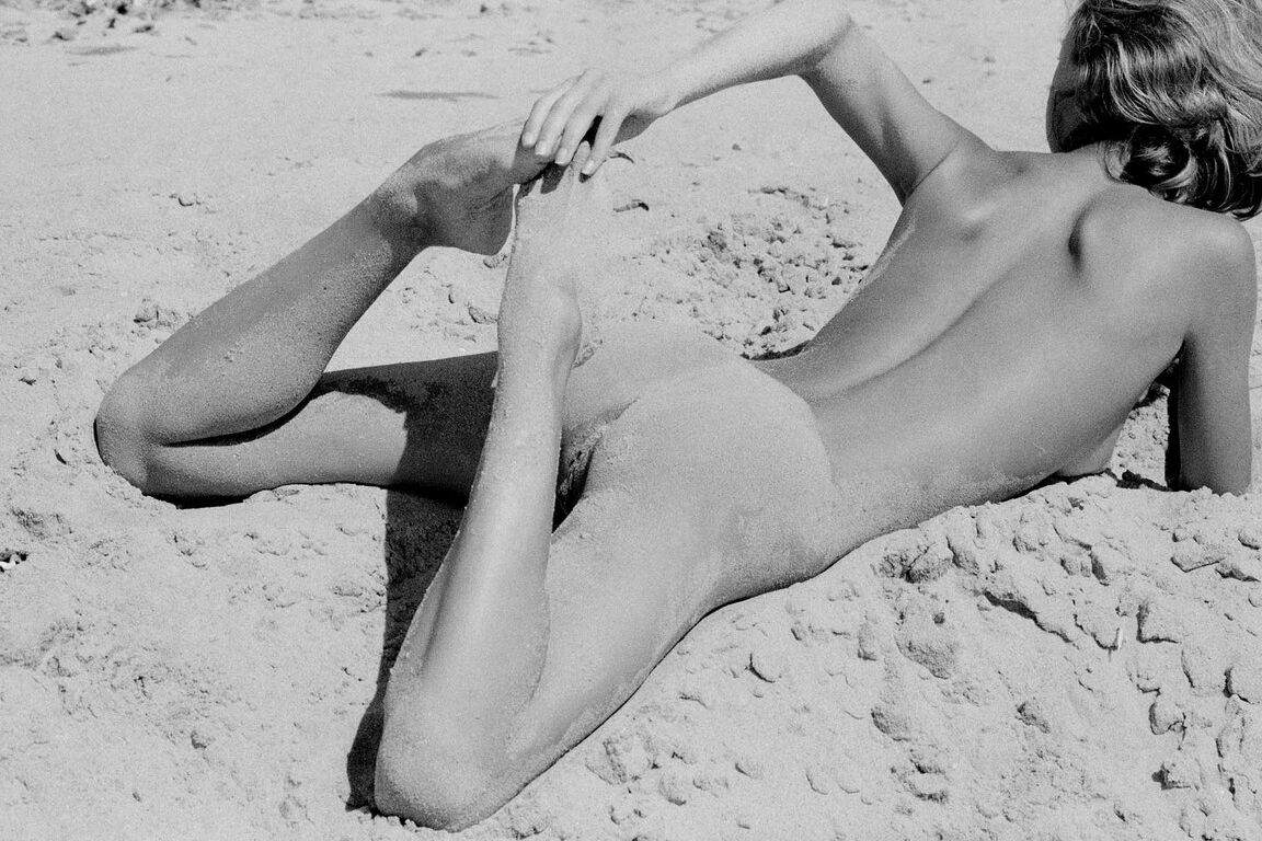 21P Barefoot babe with a skinny body Olga rubs her twat while rolling in the sand