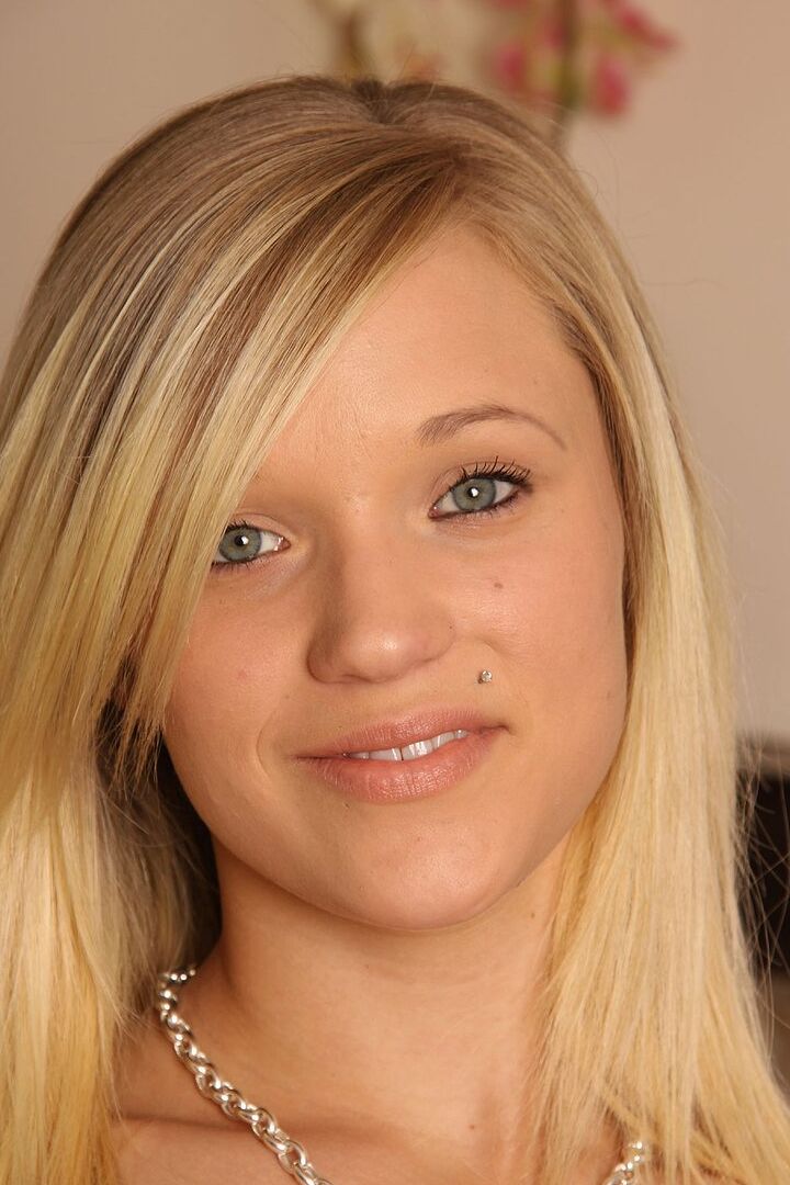 16P La joven rubia Teagan descubre sus pequeñas tetas mientras se desnuda en un sofá