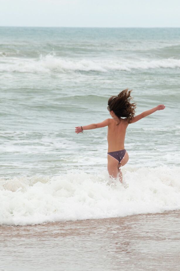 16P Mulher de topless tira a parte de baixo do biquíni para posar nua na praia