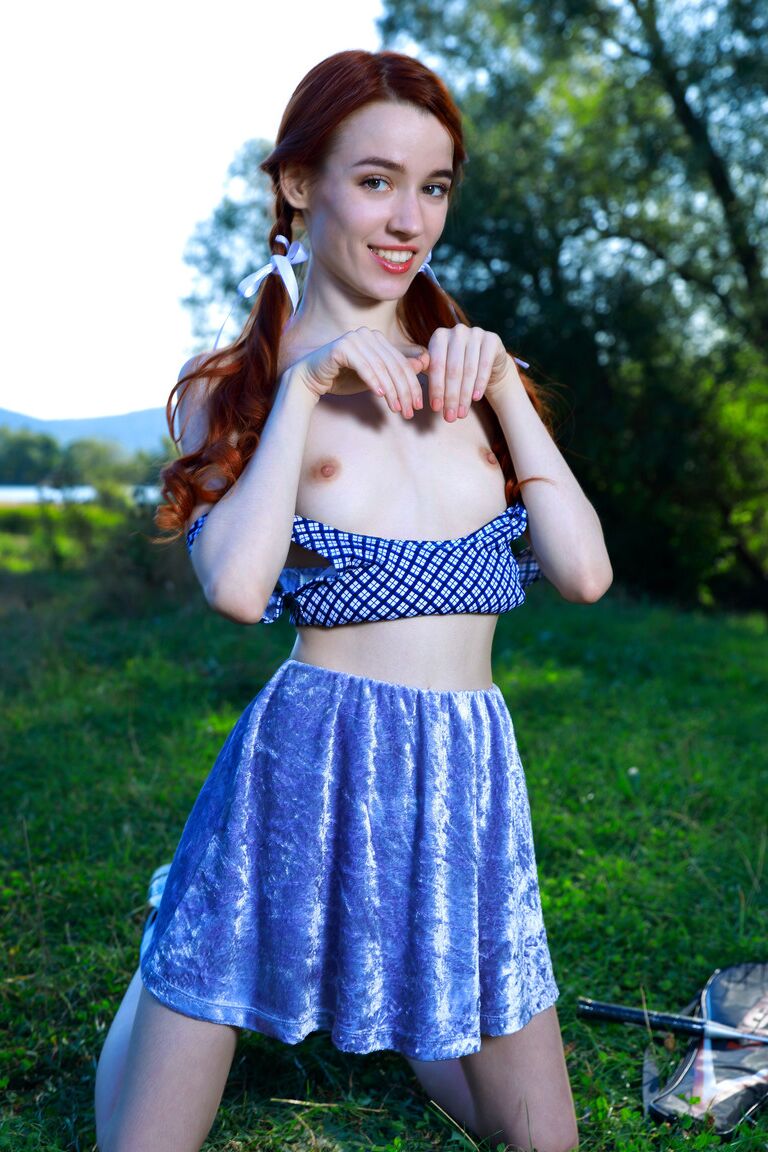 21P Redheaded teen with small tits Sherice unveils her sweet muff in a park