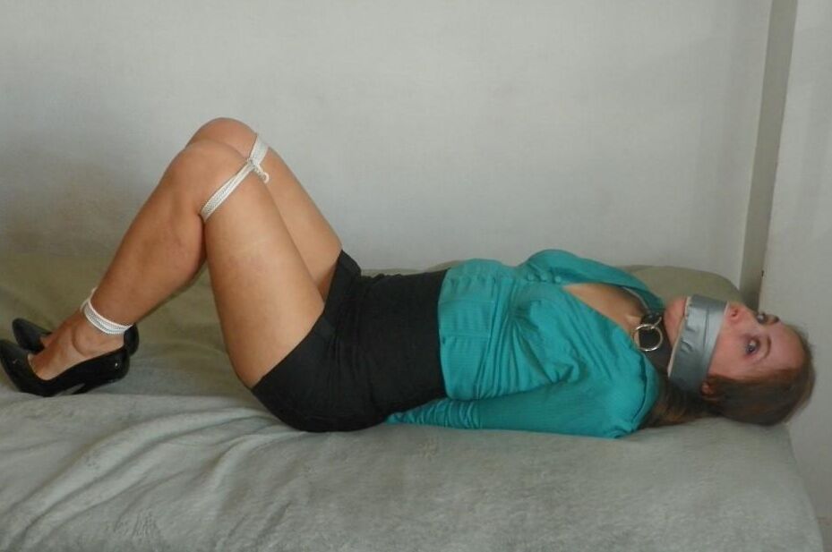 16P Collared woman is tied up on a bed in a black miniskirt and pumps