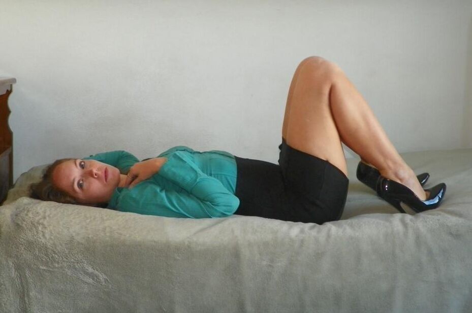 16P Collared woman is tied up on a bed in a black miniskirt and pumps