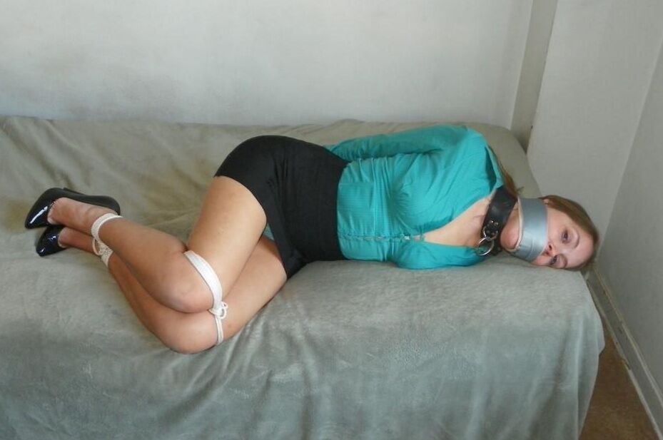 16P Collared woman is tied up on a bed in a black miniskirt and pumps