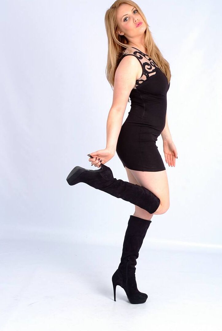 15P Solo girl Louise models black leather boots in a short dress for a SFW shoot