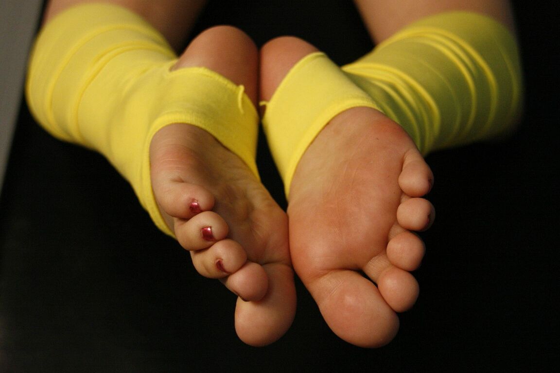 16P Mulher caucasiana brinca com os pés enquanto usa polainas amarelas