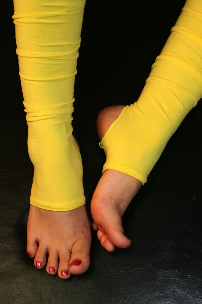 16P Mulher caucasiana brinca com os pés enquanto usa polainas amarelas