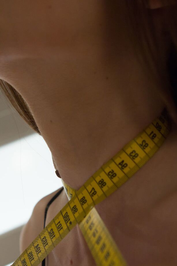 Das 16-jährige Teenie-Model Baiba B misst ihre schlanke Taille vor einem nackten Fingerfick