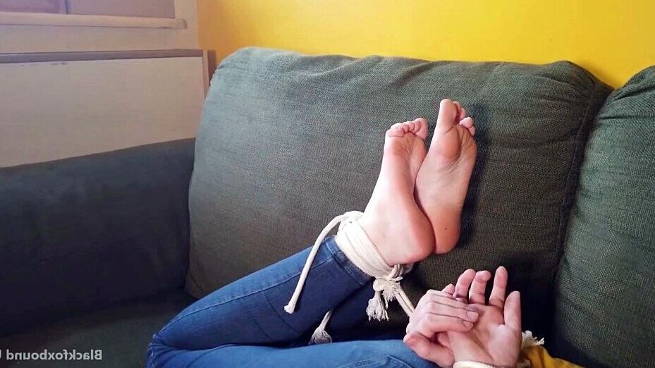 16P Кавказская женщина шевелит пальцами ног, будучи связанной одеждой.