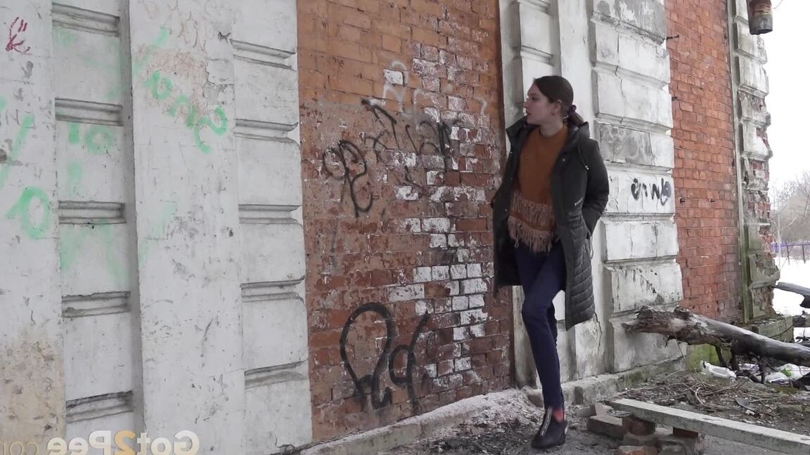 15P Brunette babe squats in a doorway to piss outside