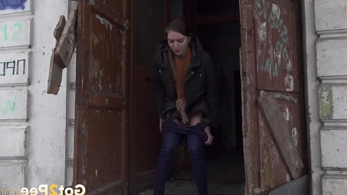 15P Brunette babe squats in a doorway to piss outside