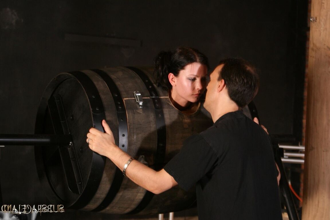 21P La brune sexy dans une boîte de bondage Goldie donne la tête à un maître brutal du BDSM