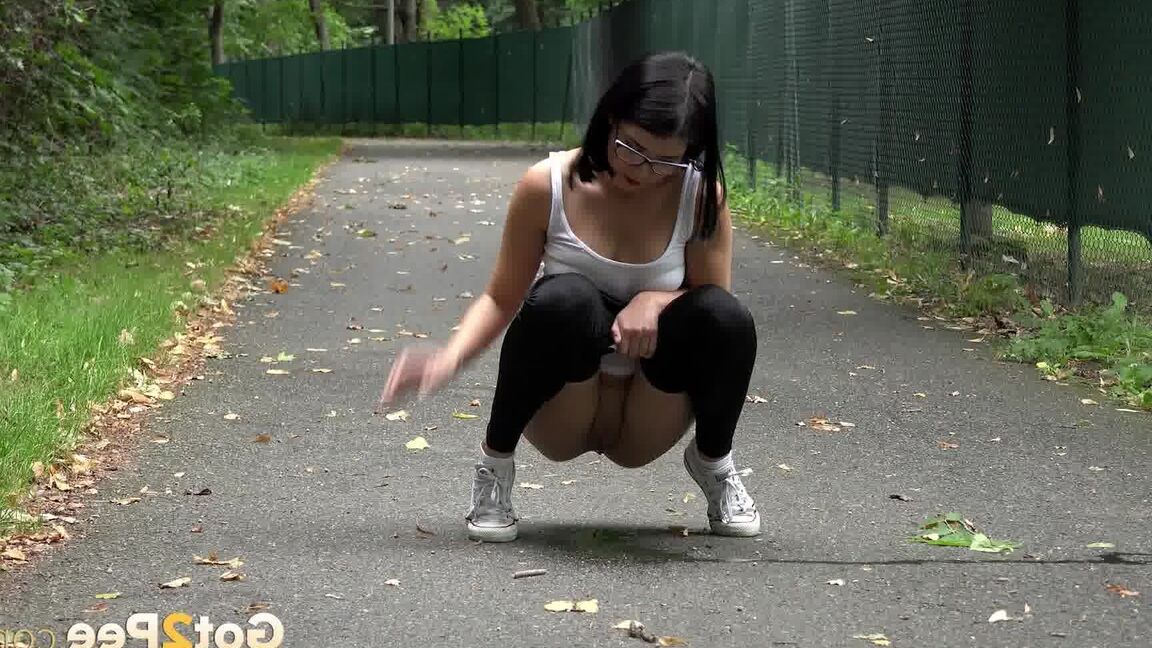 15P Glasses wearing chick pulls down her legging for a quick piss on on paved lot