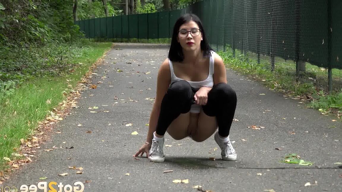 15P Glasses wearing chick pulls down her legging for a quick piss on on paved lot