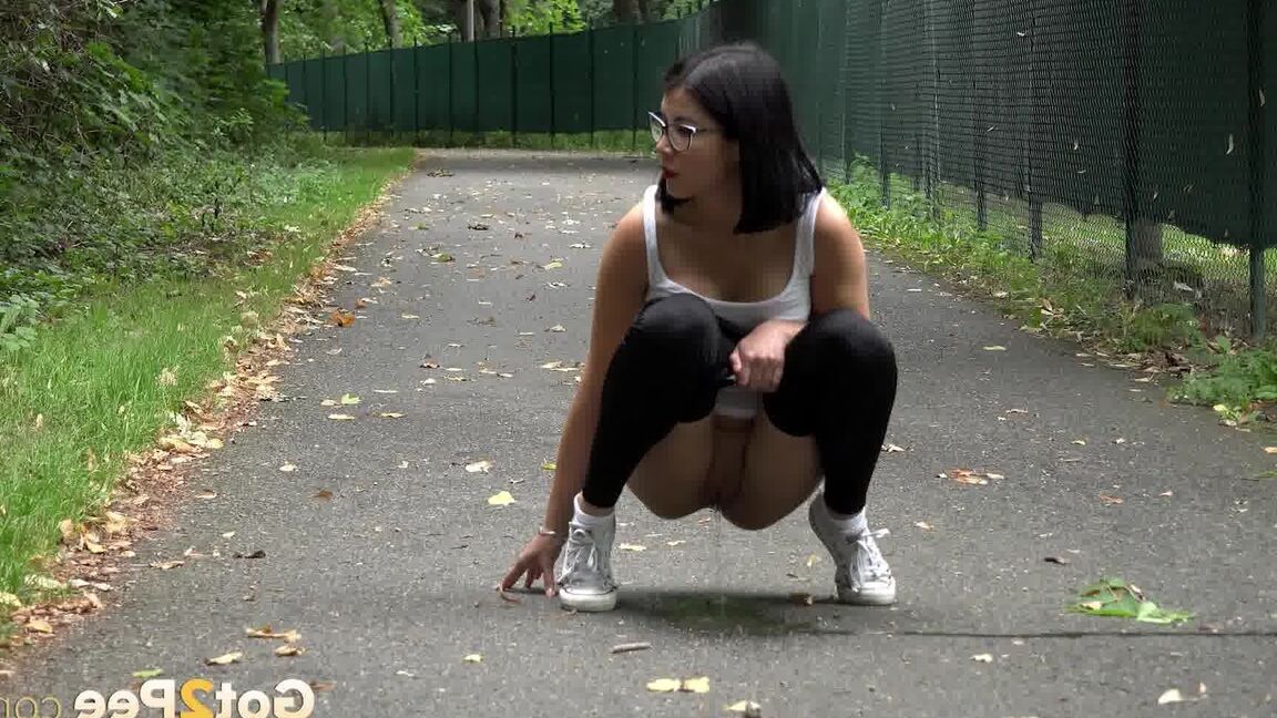 15P Glasses wearing chick pulls down her legging for a quick piss on on paved lot
