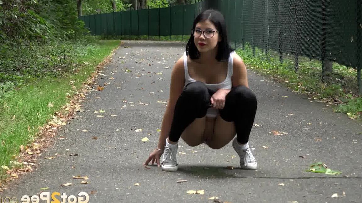 15P Glasses wearing chick pulls down her legging for a quick piss on on paved lot