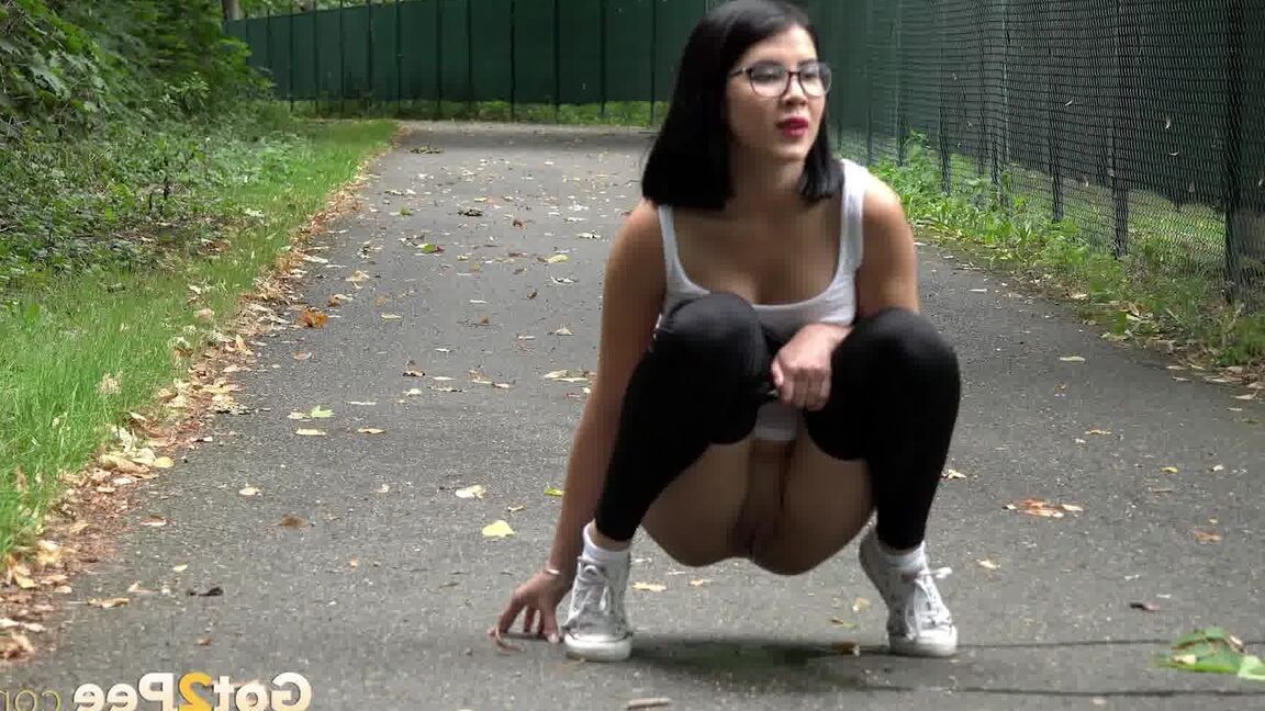 15P Glasses wearing chick pulls down her legging for a quick piss on on paved lot