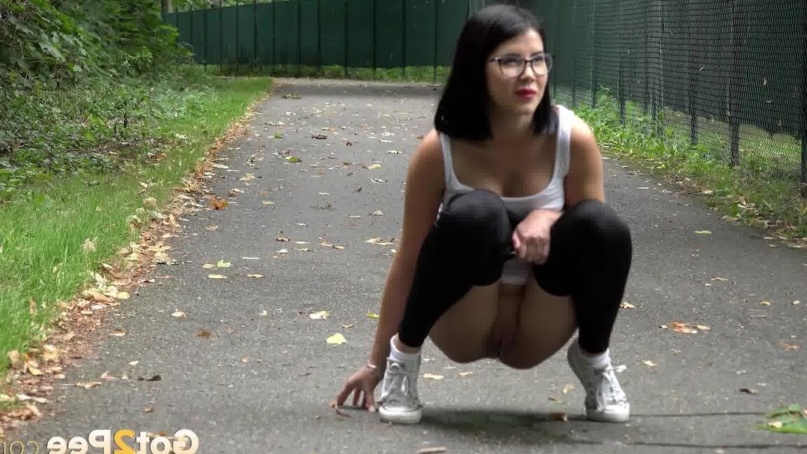 15P Glasses wearing chick pulls down her legging for a quick piss on on paved lot