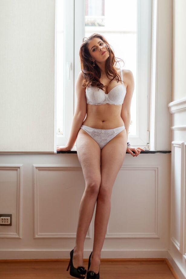 18P Gorgeous brunette Amelie Belain stands at the window in sexy lingerie and high