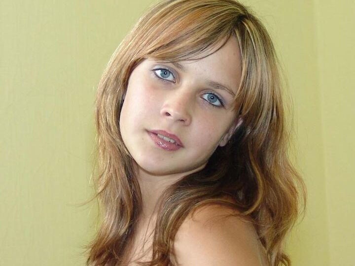 20P La douce adolescente Liza pousse ses seins fermes vers l'avant après avoir retiré sa lingerie transparente.