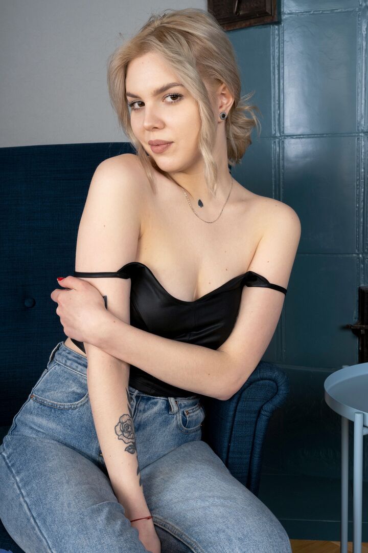 16P La belle jeune blonde Hannah Blu se déshabille complètement sur une bergère.