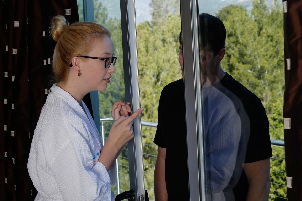 17P A massagista loira de óculos, Samantha Rone, dá as boas-vindas ao seu cliente com um roupão