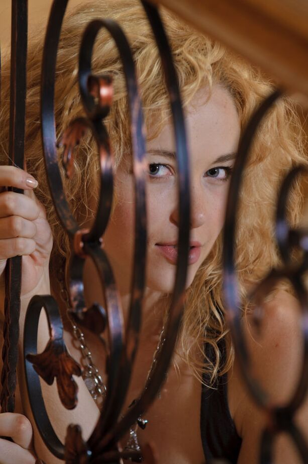 Das 16-jährige Teenie-Model Alisa G trägt welliges Haar und schlüpft dabei aus schwarzen Dessous