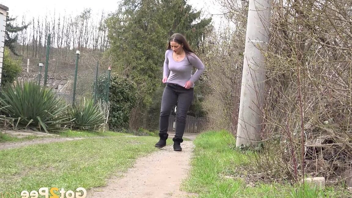 15P Nicolette Noir takes a piss while walking on a dirt path behind some homes