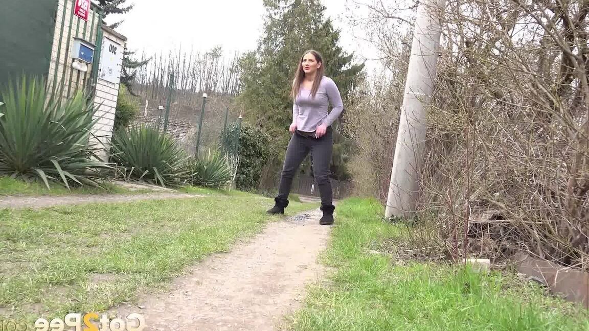 15P Nicolette Noir takes a piss while walking on a dirt path behind some homes