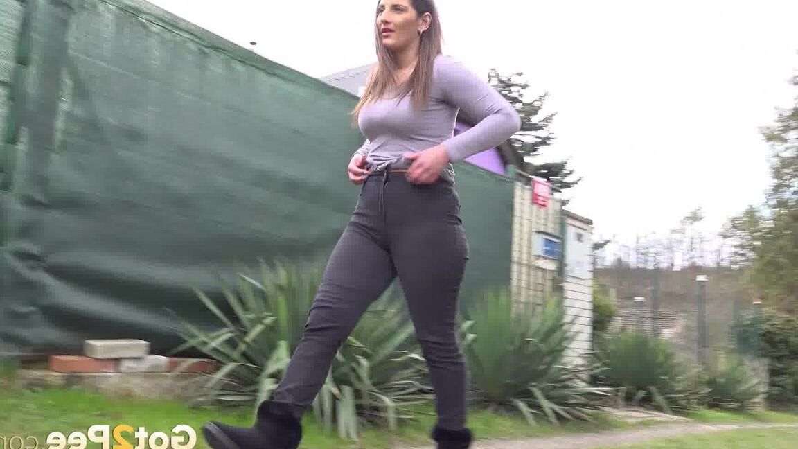 15P Nicolette Noir takes a piss while walking on a dirt path behind some homes