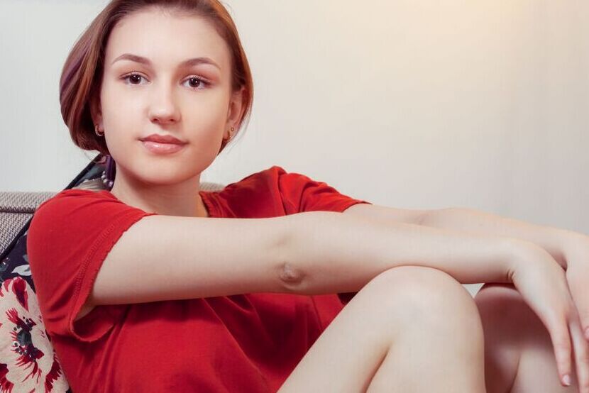 20P Young redhead Sacha fondles her tight slit after undressing on a sofa