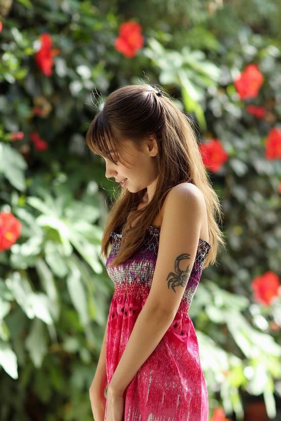 16P A doce adolescente Sofy Bee se despe em uma cadeira de pátio perto de flores desabrochando