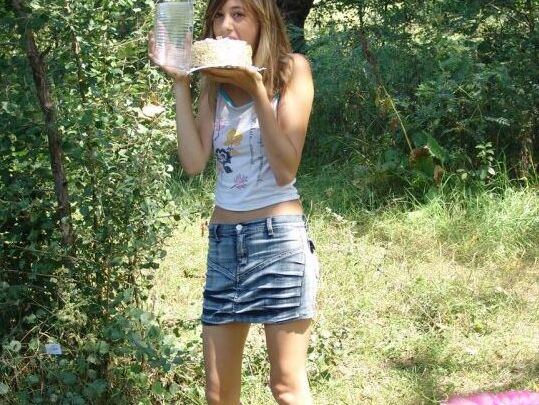 10P Young amateur eats a cake near the woods while wearing a denim miniskirt