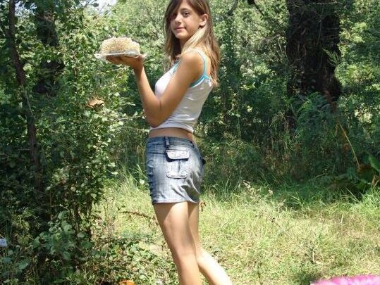 10P Young amateur eats a cake near the woods while wearing a denim miniskirt