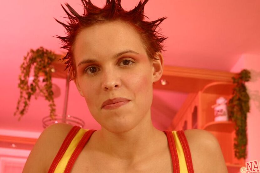 21P Janet, rousse et punk salope, montre sa chatte rasée nue avec des bottes.