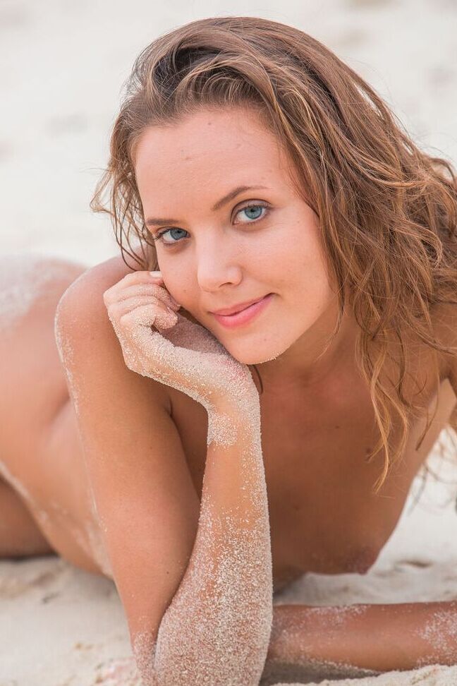 16P La pequeña adolescente Clover se desnuda totalmente en una playa de arena sin nadie alrededor