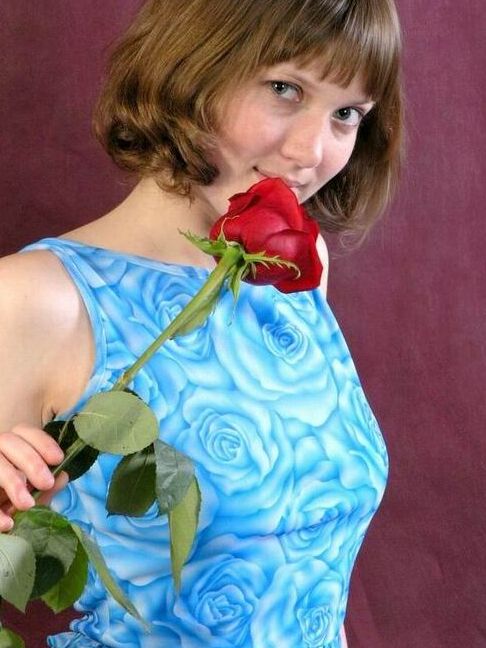 15P Die bezaubernde Teenagerin Anabell hält eine einzelne rote Rose in der Hand, während sie sich auszieht