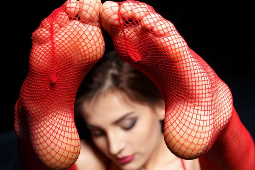 16P Marlyn portant de la lingerie rouge vif et des bas résille assortis, trempée dans