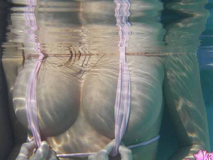 Das 12P-Amateurmodel Kate trägt einen knappen Bikini, während sie in und außerhalb eines Pools posiert